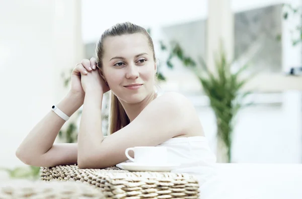Donna felice in bianco con tazza di caffè o tè in camera da letto — Foto Stock