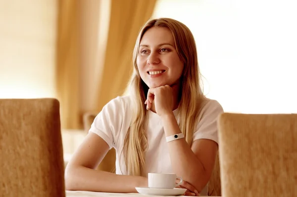 Щаслива жінка в білому з чашкою кави або чаю . — стокове фото