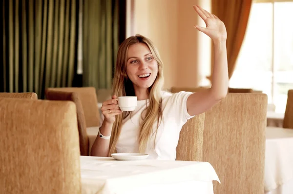 Kobieta w bieli z filiżanką kawy lub herbaty, szczęśliwy. — Zdjęcie stockowe