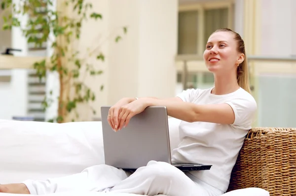 ラップトップ コンピューターを自宅で若い女性の笑顔. — ストック写真