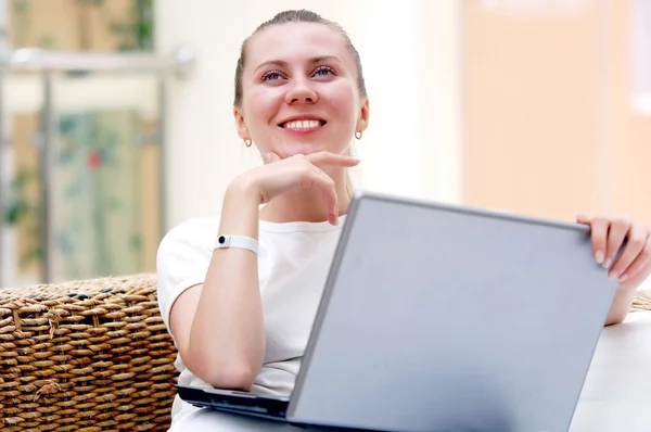 Sonriendo a las mujeres jóvenes con ordenador portátil en casa . — Foto de Stock