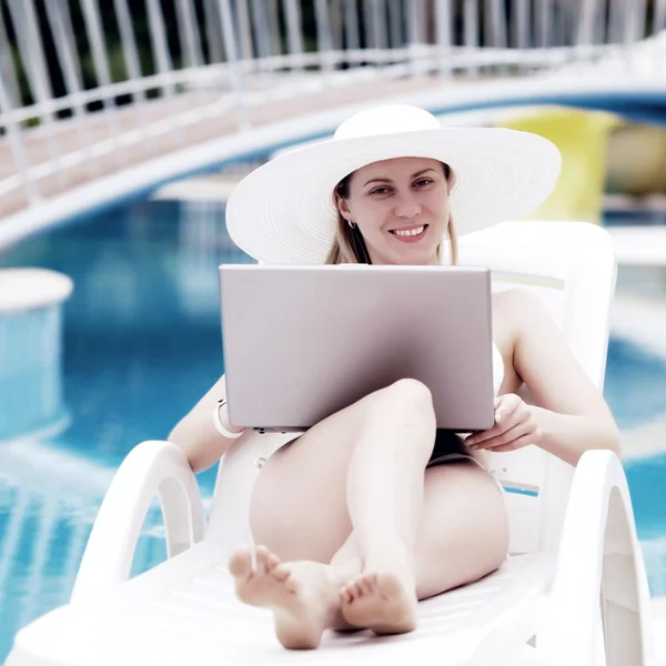 Młode kobiety relaks w pobliżu waterpool z laptopa. — Zdjęcie stockowe