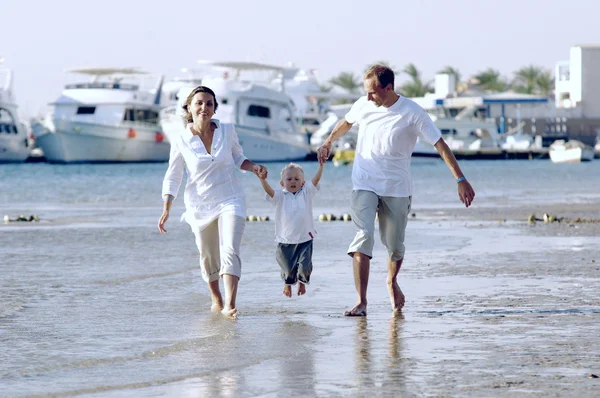 Visa glada unga familj att ha kul på stranden — Stockfoto