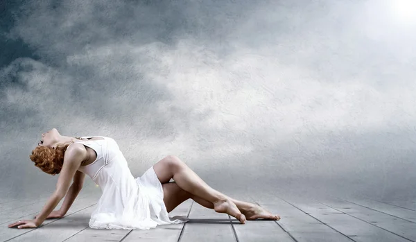 Mujer bailarina sentada posando sobre fondo — Foto de Stock