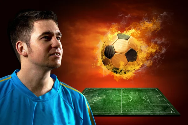 Футболист и огненный мяч на поле — стоковое фото