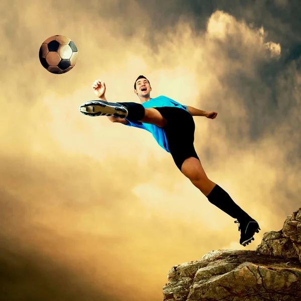 Fotbollsspelare på toppen av berg — Stockfoto