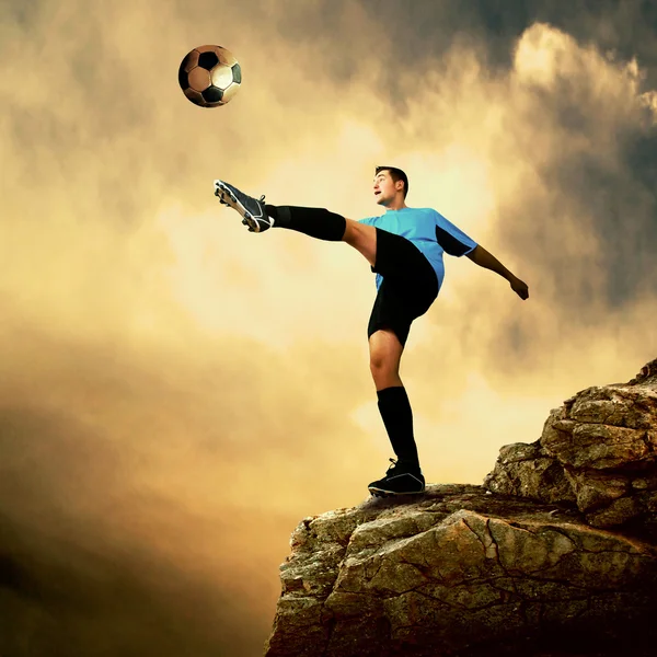 Futbolista en la cima de la montaña — Foto de Stock