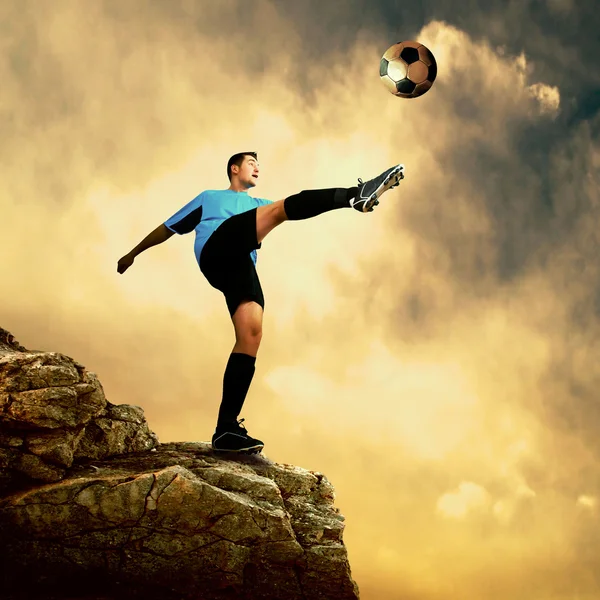 Futbolista en la cima de la montaña — Foto de Stock