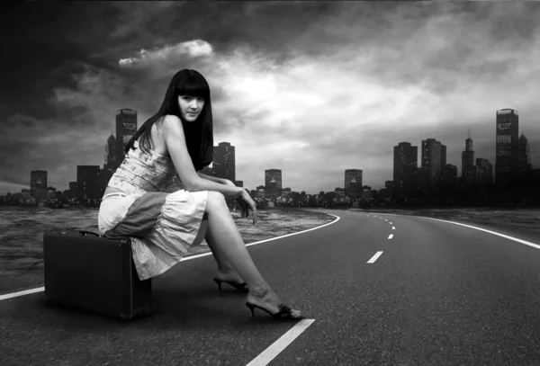 Joven mujer esperando en la carretera con su equipaje vintage —  Fotos de Stock