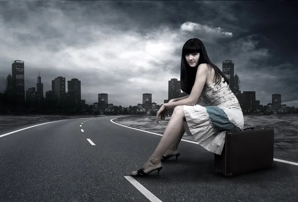 Νεαρή γυναίκα που περιμένει στο δρόμο με το εκλεκτής ποιότητας αποσκευές — Φωτογραφία Αρχείου