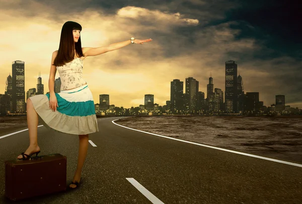 Ung kvinna väntar på väg med hennes vintage bagage — Stockfoto