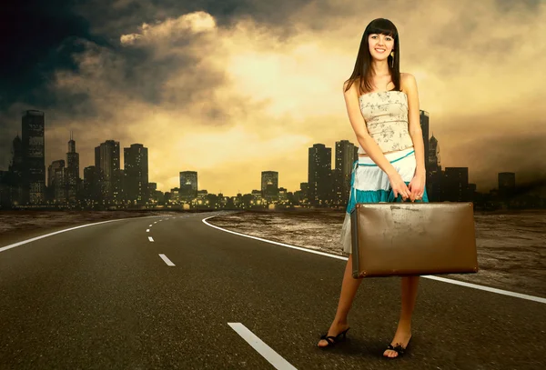 Mladá žena čekající na silnici s její vinobraní zavazadla — Stock fotografie