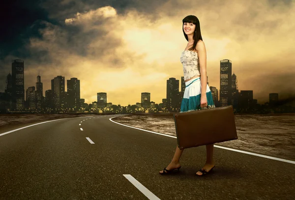 Young woman waiting on the road with her vintage baggage — Stock Photo, Image