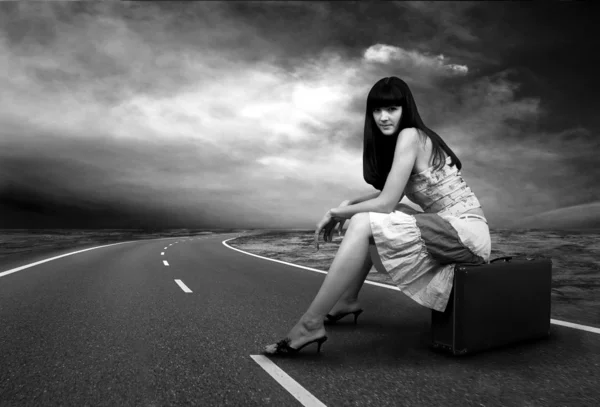 Junge Frau wartet mit ihrem Oldtimer-Gepäck auf der Straße — Stockfoto