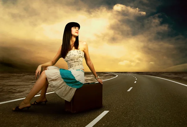 Fiatal nő az úton, ő vintage poggyásszal vár — Stock Fotó