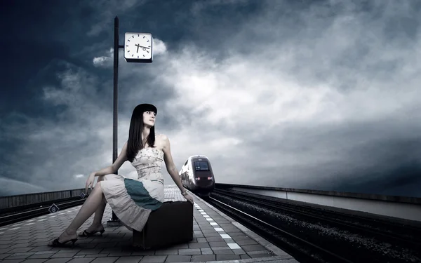 Дівчина чекає потяг на платформі залізничного вокзалу — стокове фото