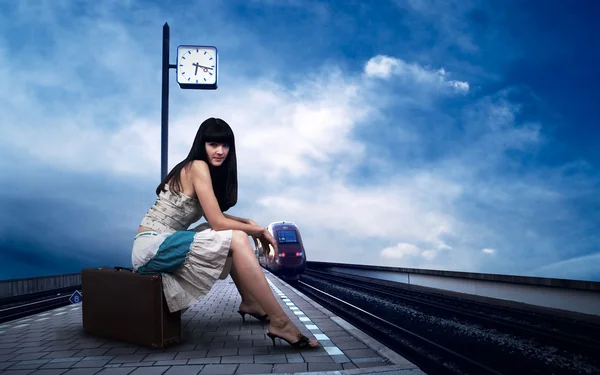 Dziewczyna czeka pociąg na peronie dworca kolejowego — Zdjęcie stockowe