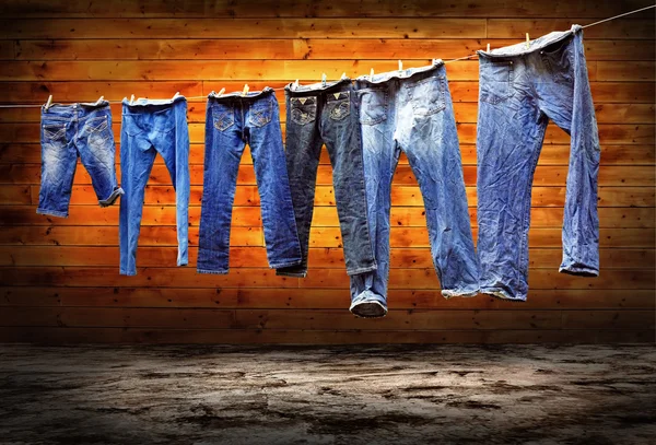Džíny na prádelní šňůře sušit na pozadí grunge — Stock fotografie