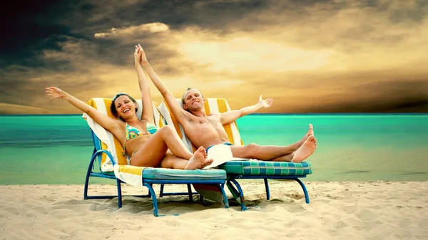 Вид ззаду пари на стілець на палубі, що розслабляється на пляжі — стокове фото