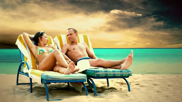 Вид ззаду пари на стілець на палубі, що розслабляється на пляжі — стокове фото