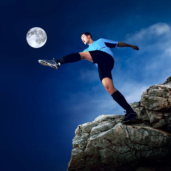 Footballer on the top of mountain at moon night — Stock Photo, Image