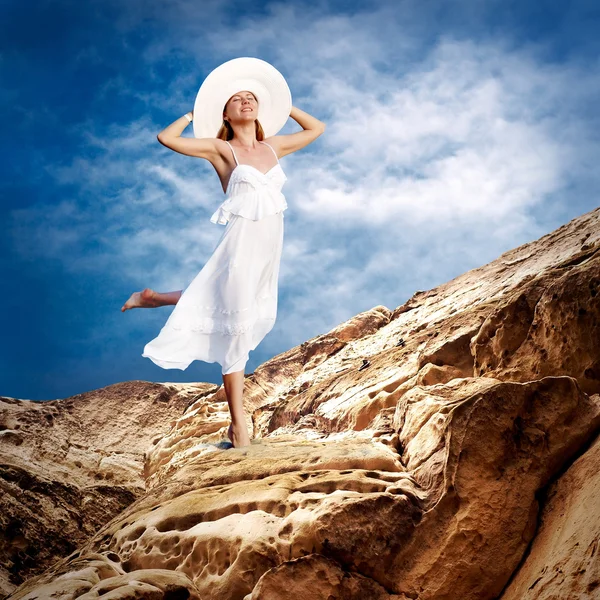 Schönes Mädchen in Weiß auf dem Brunnen unter dem Himmel mit Wolken — Stockfoto