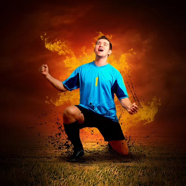Jogador de futebol em fogos chama no campo ao ar livre — Fotografia de Stock