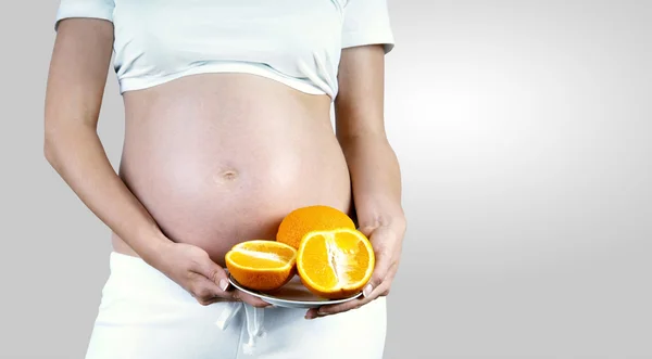 Bonheur femmes enceintes dans le blanc avec de l'orange — Photo