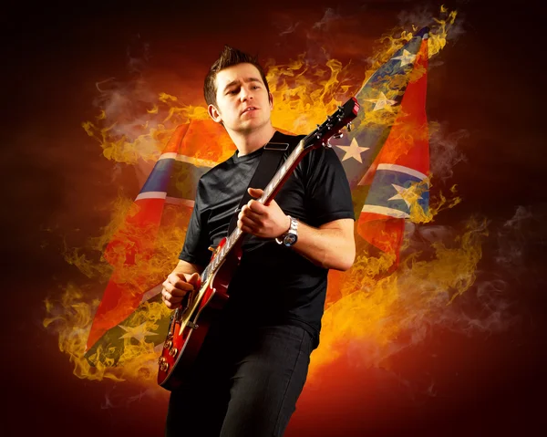 Рок-гитарист играет на электрогитаре вокруг огня — стоковое фото