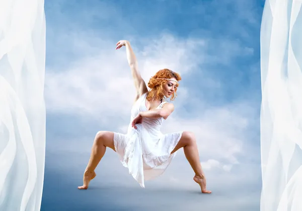 Žena tanečnice skok pózuje na pozadí — Stock fotografie