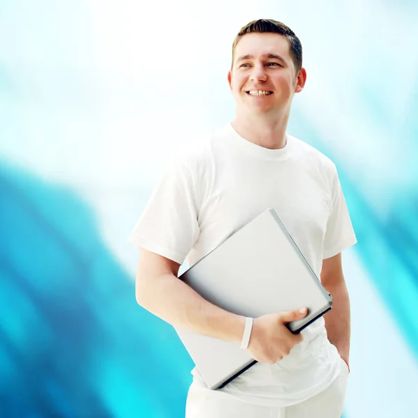 Jeune homme heureux ou étudiant avec ordinateur portable sur le backgroun d'affaires — Photo
