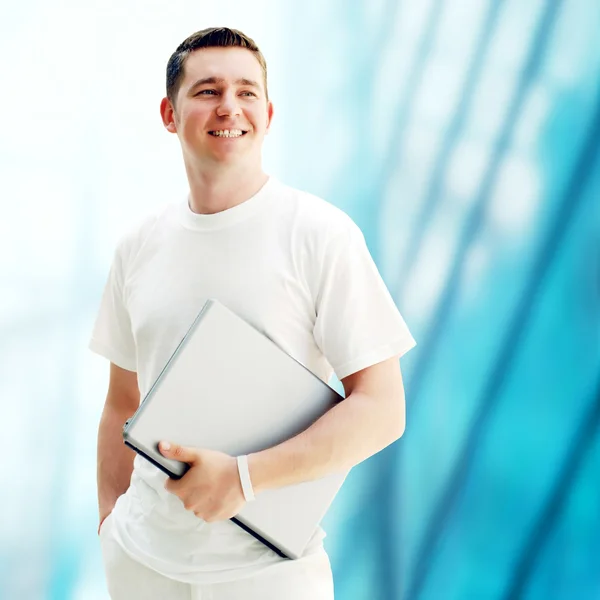 Young happy man or student with laptop on the business backgroun — Stock Photo, Image