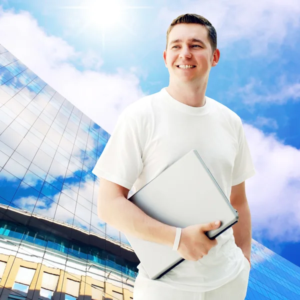 Young happy man or student with laptop on the business backgroun — Stock Photo, Image