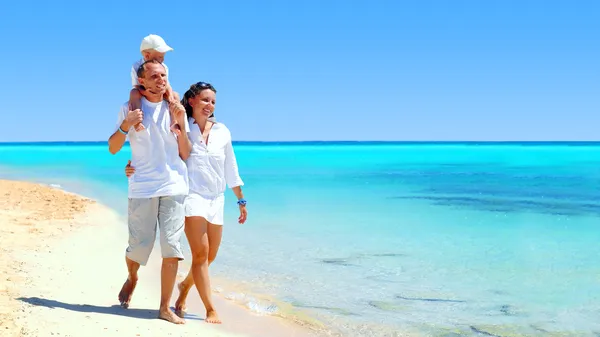Vista da família jovem feliz se divertindo na praia Imagens Royalty-Free