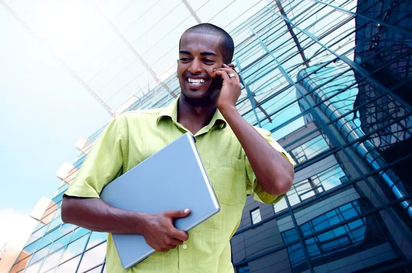 Молодий щасливий чоловік або студент з ноутбуком і телефоном в бізнесі Стокове Зображення