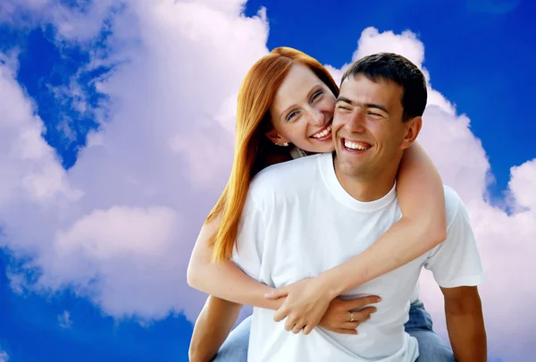 푸른 하늘 아래 웃는 젊은 사랑 부부 스톡 사진