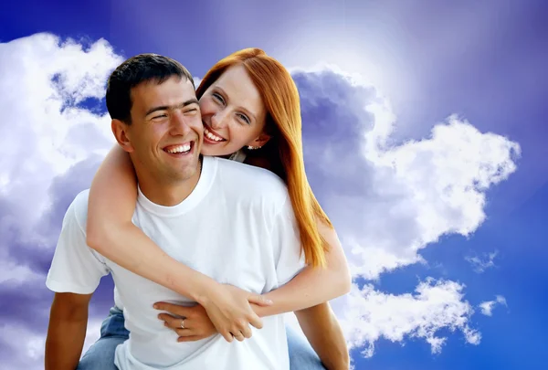 Young love couple smiling under blue sky Stock Photo
