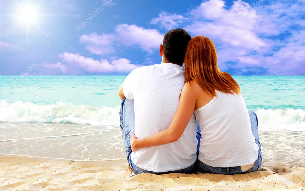 Sea view of a couple sitting on beach.