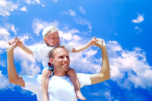 Χαρούμενη πατέρα δίνοντας piggyback βόλτα στον γιο του ουρανό bac — Φωτογραφία Αρχείου