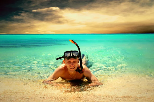 Χαρούμενος νεαρός με κολύμβηση με αναπνευστήρα σε μια παραλία στη θάλασσα — Φωτογραφία Αρχείου