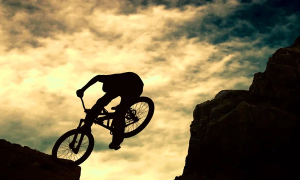 Bir adam muontain-bisiklet, gün batımı silüeti — Stok fotoğraf