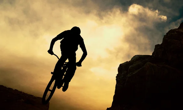 Sylwetka człowieka na ograniczonej rower, zachód słońca — Zdjęcie stockowe
