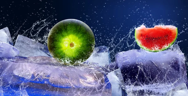 Вода падає навколо кавуна на льоду — стокове фото