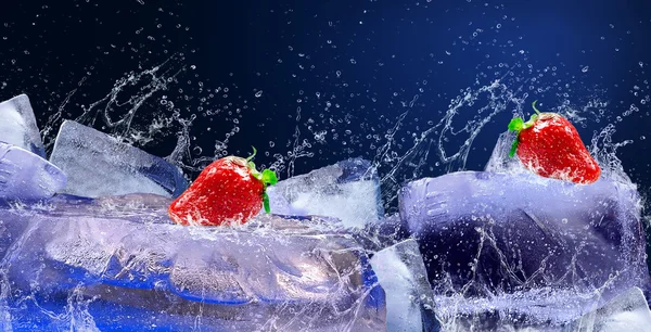 Вода падає навколо полуниці та льоду на синьому фоні — стокове фото