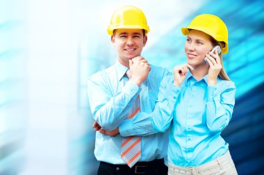 Young architects wearing a protective helmet standing on the bui clipart