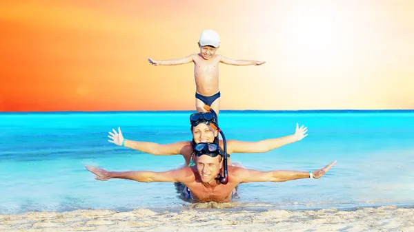 Jovem casal feliz e filho com snorkelling em uma praia do mar — Fotografia de Stock