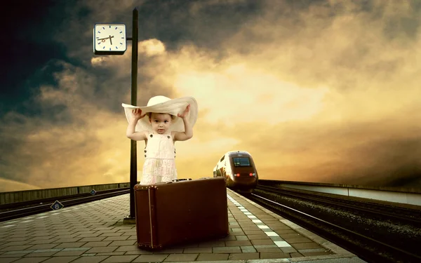 Liten flicka sitter på vintage bagage på tåget plattform — Stockfoto