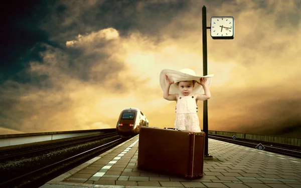 Dziewczynka siedzi na sztuka bagażu na platformie kolejowej — Zdjęcie stockowe