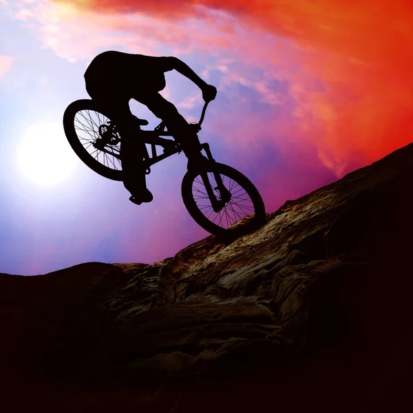 La silueta de un hombre en moto de montaña, puesta de sol —  Fotos de Stock
