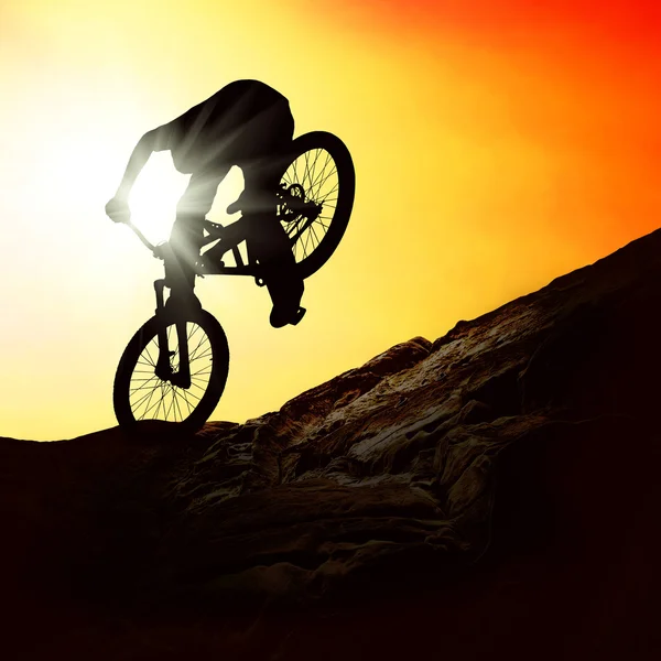 Silueta muže na muontain-na kole, při západu slunce — Stock fotografie